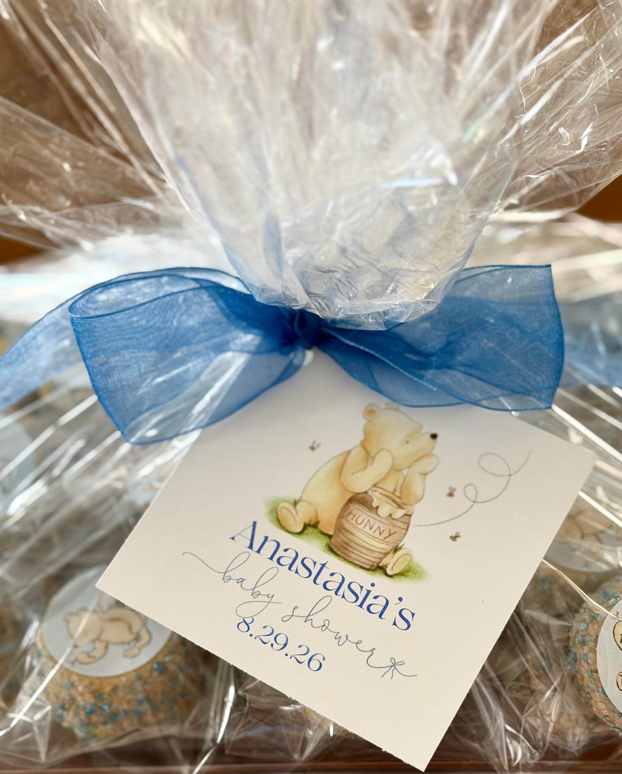 Winnie the Pooh baby shower favor wrapped in cellophane with a blue bow